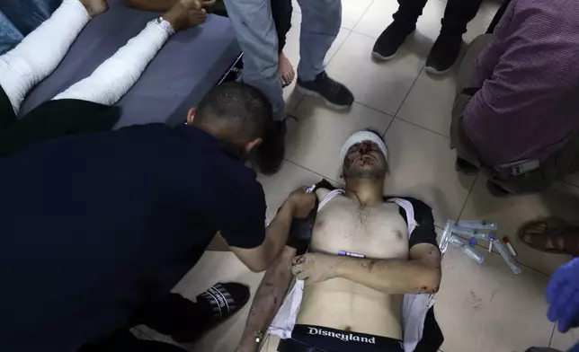 Palestinian medics treat a wounded youth in the Israeli bombardment on a residential building owned by the Jabr family in Bureij refugee camp, at al-Aqsa Martyrs Hospital in Deir al Balah, central Gaza Strip, Wednesday, June 12, 2024. (AP Photo/Saher Alghorra)