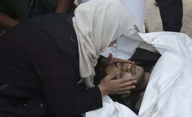 A Palestinian woman takes a last look at a loved one killed by Israeli bombardment, before his burial in Khan Younis, southern Gaza Strip, Friday, June 21, 2024. (AP Photo /Jehad Alshrafi)
