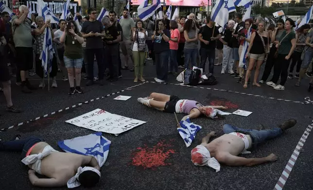 Demonstrators are painted red, symbolizing blood during a protest against Israeli Prime Minister Benjamin Netanyahu's government and demanding elections, in Tel Aviv, Israel, Saturday, June 22, 2024. (AP Photo/Leo Correa)