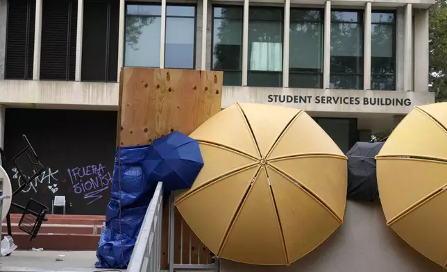 A barricade and graffiti are seen left by pro-Palestinian protesters at the Student Services Building at California State University, Los Angeles campus in Los Angeles, Thursday, June 13, 2024. A takeover of a building at the university by demonstrators protesting Israel's war against Hamas in Gaza ended early Thursday, leaving the facility trashed and covered with graffiti. (AP Photo/Damian Dovarganes)