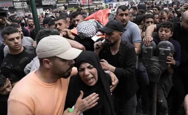 FILE - Mourners carry the body of Samer Rumaneh, draped in a Palestinian flag, who was killed in an Israeli military raid, during his funeral in the West Bank city of Nablus, on May 12, 2024. An AP analysis of Gaza Health Ministry data finds the proportion of Palestinian women and children being killed in the Israel-Hamas war appears to have declined sharply. Israel faces heavy international criticism over unprecedented levels of civilian casualties in Gaza. (AP Photo/Majdi Mohammed)