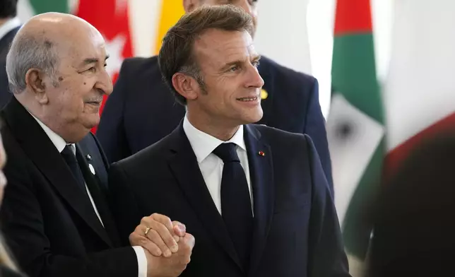 French President Emmanuel Macron, right shakes hands with Algerian President Abdelmadjid Tebboune during a working session on AI, Energy, Africa and Mideast at the G7 summit, in Borgo Egnazia, near Bari in southern Italy, Friday, June 14, 2024. (AP Photo/Andrew Medichini)