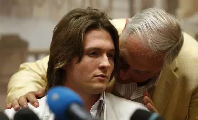 FILE - Raffaele Sollecito listens to his father Francesco Sollecito, right, during a press conference in Rome, Tuesday, July 1, 2014. Amanda Knox returns to an Italian courtroom Wednesday June 5, 2024, for the first time in more than 12½ years to clear herself ‘once and for all’ of a slander charge that stuck even after she was exonerated in the brutal 2007 murder of her British roommate in the idyllic hilltop town of Perugia. (AP Photo/Riccardo De Luca, File)