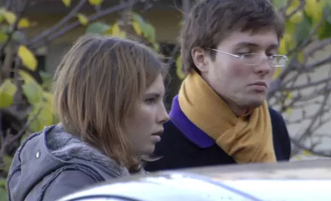 FILE - American exchange student Amanda Knox, left, and her Italian boyfriend Raffaele Sollecito outside the rented house where 21-year-old British student Meredith Kercher was found dead in Perugia, Italy, Nov. 2, 2007. Amanda Knox is expected to appear in person in an Italian court to defend herself in a slander case that has the potential to remove the last legal stain against her, following her exoneration nine years ago in the 2007 murder of her British roommate, Meredith Kercher. (AP Photo/Stefano Medici, File)