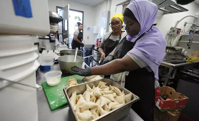 Cooks prepare East African cuisine at the Baobab Fare restaurant, Friday, May 24, 2024, in Detroit. For Hamissi Mamba and Nadia Nijimbere _ who own Baobab Fare in Detroit _ a win among the five finalists in the James Beard's "Outstanding Restaurateur" category would be personal. The couple, who fled Burundi about a decade ago, faced a difficult road as refugees opening a business in America. (AP Photo/Carlos Osorio)