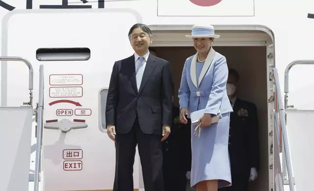 Japanese Emperor Naruhito, left, and Empress Masako smile as they depart for the state visit to Britain, at Haneda airport in Tokyo, Japan, Saturday, June 22, 2024. (Kyodo News via AP)