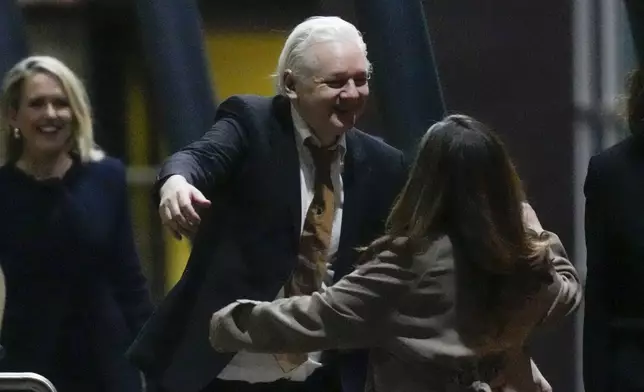 WikiLeaks founder Julian Assange embraces his wife Stella after landing at RAAF air base Fairbairn in Canberra, Australia, Wednesday, June 26 2024. Assange has returned to his homeland Australia aboard a charter jet hours after pleading guilty to obtaining and publishing U.S. military secrets in a deal with Justice Department prosecutors that concludes a drawn-out legal saga.(AP Photo/Rick Rycroft)