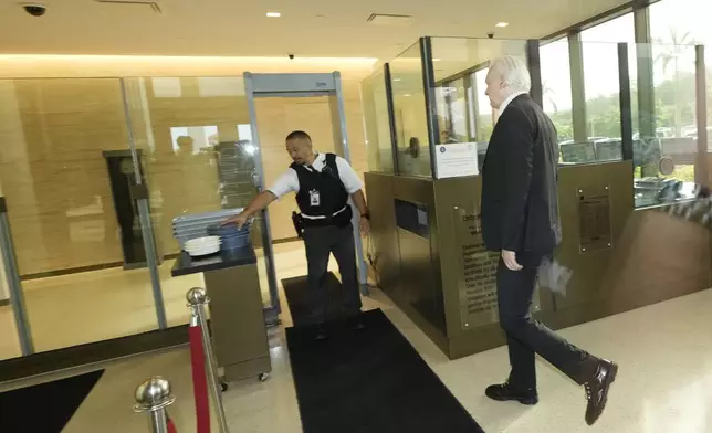 WikiLeaks founder Julian Assange, right, arrives and goes through security at the United States courthouse where he is expected enter a plea deal, in Saipan, Mariana Islands, Wednesday, June 26 2024. (AP Photo/Eugene Hoshiko)