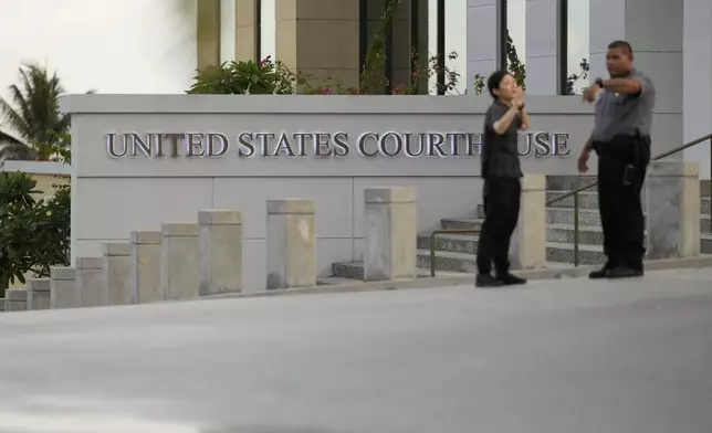 Officials outside the courthouse where WikiLeaks founder Julian Assange is expected to enter a plea deal, in Saipan, Mariana Islands, Wednesday, June 26 2024. (AP Photo/Eugene Hoshiko)