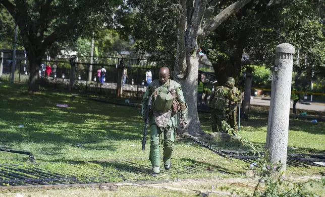 Kenya anti riot police patrol around parliament compound in downtown Nairobi, Kenya, Wednesday, June 26, 2024. Thousands of protesters stormed and burned a section of Kenya's parliament Tuesday to protest tax proposals. Police responded with gunfire and several protesters were killed. (AP Photo/Brian Inganga)