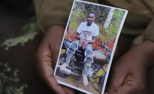 Edith Wanjiku shows a photo of his son 19-year-old Ibrahim Kamau at her home in the Majengo low-income neighborhood in Nairobi, Kenya Friday, June 28, 2024. Kamau was shot during a protest on Tuesday against the government proposed tax bill. Protesters stormed parliament on Tuesday and drew police fire in chaos that left several people dead. (AP Photo/Brian Inganga)