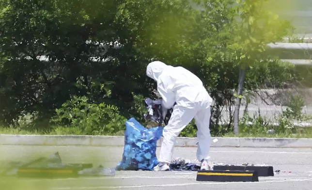 An officer wearing protective gear collects the trash from a balloon presumably sent by North Korea, in Siheung, South Korea, Sunday, June 2, 2024. South Korea said Sunday it’ll take strong retaliatory steps against North Korea over its launch of trash-carrying balloons and other provocations on South Korea. (Hong Ki-won/Yonhap via AP)