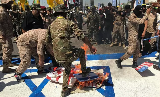 FILE - Popular Mobilization Forces burn representations of U.S. and Israeli flags during "al-Quds" Day, Arabic for Jerusalem, in Baghdad, Iraq, May 31, 2019. Thousands of fighters from Iran-backed groups in the Middle East are offering to come to Lebanon to join the militant Hezbollah group in its fight with Israel. (AP Photo/Ali Abdul Hassan, File)