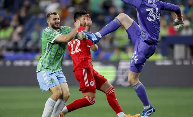 Chicago Fire goalkeeper Chris Brady clears the ball past Seattle Sounders forward Jordan Morris, left, and Fire defender Mauricio Pineda during the second half of an MLS soccer match Saturday, June 29, 2024 in Seattle. (Jennifer Buchanan/The Seattle Times via AP)