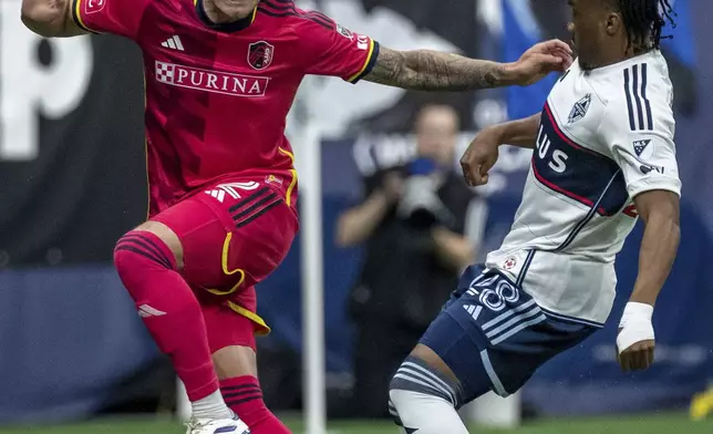 Vancouver Whitecaps' Levonte Johnson, right, and St. Louis City's Jake Nerwinski vie for the ball during the first half of an MLS soccer match Saturday, June 29, 2024, in Vancouver, British Columbia. (Ethan Cairns/The Canadian Press via AP)