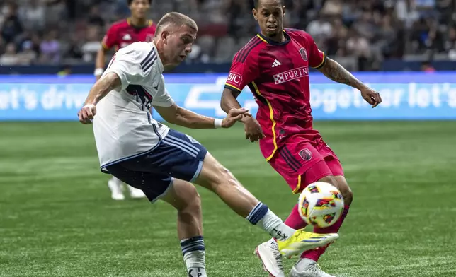 Vancouver Whitecaps' Giuseppe Bovalina, left, kicks the ball in front of St. Louis City's Akil Watts during the second half of an MLS soccer match Saturday, June 29, 2024, in Vancouver, British Columbia. (Ethan Cairns/The Canadian Press via AP)