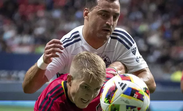 Vancouver Whitecaps' Luis Martins, back, and St. Louis City's John Klein vie for the ball during the first half of an MLS soccer match Saturday, June 29, 2024, in Vancouver, British Columbia. (Ethan Cairns/The Canadian Press via AP)