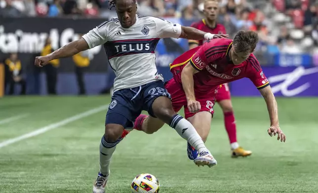 St. Louis City's Chris Durkin, right, trips during a collision with Vancouver Whitecaps' Levonte Johnson during the first half of an MLS soccer match Saturday, June 29, 2024, in Vancouver, British Columbia. (Ethan Cairns/The Canadian Press via AP)