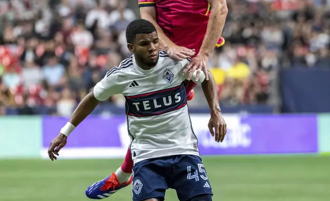 St. Louis City's Chris Durkin, top, and Vancouver Whitecaps' Pedro Vite (45) vie for the ball during the first half of an MLS soccer match Saturday, June 29, 2024, in Vancouver, British Columbia. (Ethan Cairns/The Canadian Press via AP)