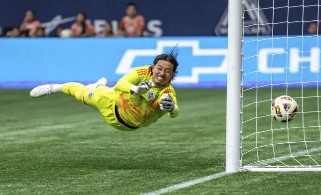 Vancouver Whitecaps goalkeeper Yohei Takaoka tries to stop a goal from St. Louis City's Njabulo Blom during the first half of an MLS soccer match Saturday, June 29, 2024, in Vancouver, British Columbia. (Ethan Cairns/The Canadian Press via AP)