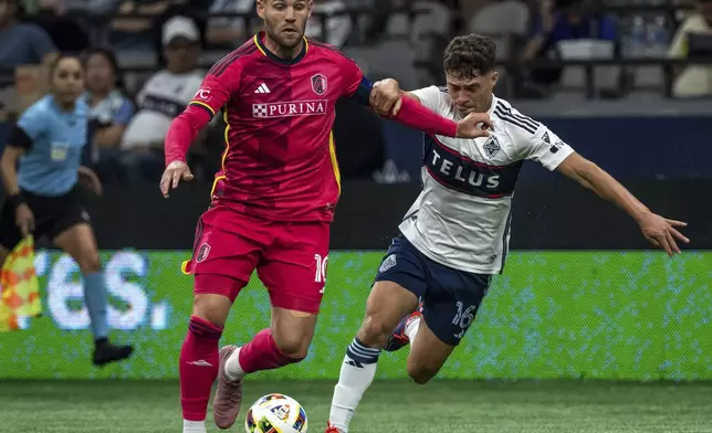 St. Louis City's Eduard Loewen, left, and Vancouver Whitecaps' Sebastian Berhalter, right, vie for the ball during the first half of an MLS soccer match Saturday, June 29, 2024, in Vancouver, British Columbia. (Ethan Cairns/The Canadian Press via AP)