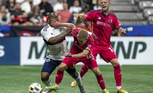 Vancouver Whitecaps' Levonte Johnson, left, and St. Louis City's John Klein (41) and Tomas Totland, right, vie for the ball during the first half of an MLS soccer match Saturday, June 29, 2024, in Vancouver, British Columbia. (Ethan Cairns/The Canadian Press via AP)