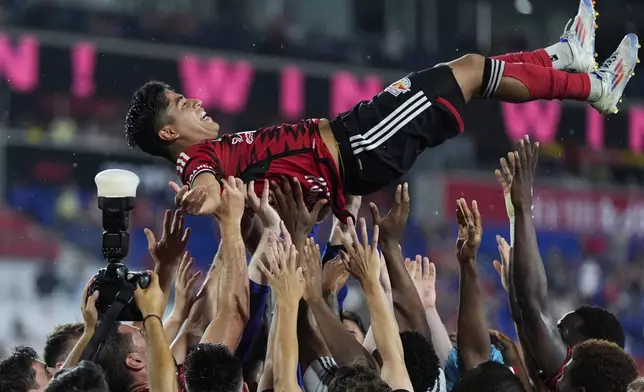 New York Red Bulls players toss up midfielder Frankie Amaya following an MLS soccer match against Toronto FC, Saturday, June 22, 2024, in Harrison, N.J. (AP Photo/Julia Nikhinson)