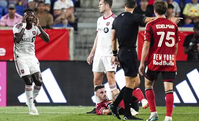 Toronto FC midfielder Deybi Flores, left, reacts after fouling New York Red Bulls' Daniel Edelman, bottom right, during an MLS soccer match, Saturday, June 22, 2024, in Harrison, N.J. (AP Photo/Julia Nikhinson)