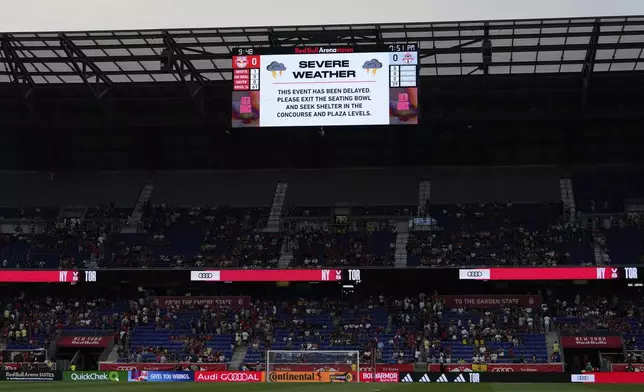 A severe weather delay is announced on a videoboard during an MLS soccer match between the New York Red Bulls and Toronto FC, Saturday, June 22, 2024, in Harrison, N.J. (AP Photo/Julia Nikhinson)