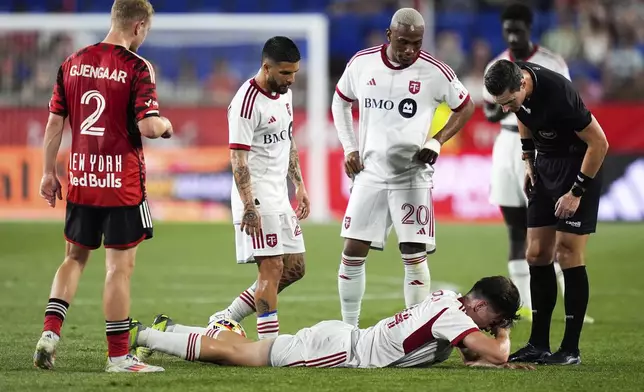 Toronto FC midfielder Alonso Coello, bottom, lies on the field following an injury during an MLS soccer match against the New York Red Bulls, Saturday, June 22, 2024, in Harrison, N.J. (AP Photo/Julia Nikhinson)