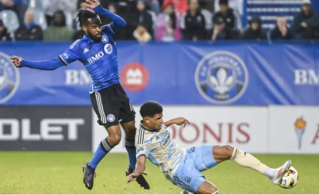 Philadelphia Union's Nathan Harriel, right, slides in on CF Montreal's Raheem Edwards (44) during the first half of an MLS soccer match Saturday, June 29, 2024, in Montreal. (Graham Hughes/The Canadian Press via AP)