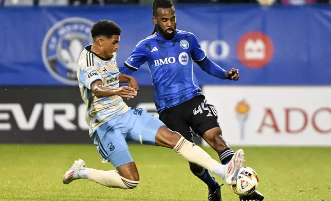 Philadelphia Union's Nathan Harriel, left, slides in on CF Montreal's Raheem Edwards (44) during the first half of an MLS soccer match Saturday, June 29, 2024, in Montreal. (Graham Hughes/The Canadian Press via AP)
