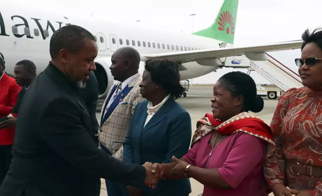 FILE - Malawi Vice President Saulos Chilima, left, greets government officials upon his return from South Korea in Lillongwe, Sunday, June 9, 2024. Malawi’s vice president and nine others have been killed in a plane crash, the country’s president said Tuesday. The wreckage of the military plane carrying Vice President Saulos Chilima was located in a mountainous area in the north of the country after a search that lasted more than a day. There were no survivors of the crash, Malawian President Lazarus Chakwera said. Chakwera made the announcement in a live address on state television. (AP Photo, File)