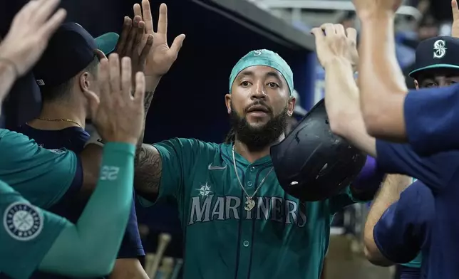 Seattle Mariners' J.P. Crawford (3) scores during the first inning of a baseball game against the Miami Marlins, Friday, June 21, 2024, in Miami. (AP Photo/Marta Lavandier)