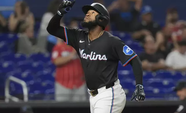 Miami Marlins' Bryan De La Cruz gestures after hitting a solo home run during the sixth inning of a baseball game against the Seattle Mariners, Friday, June 21, 2024, in Miami. (AP Photo/Marta Lavandier)