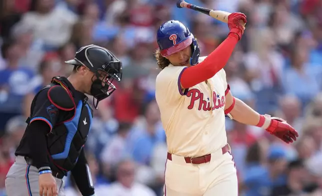 Philadelphia Phillies' Alec Bohm, right, reacts after hitting a RBI-sacrifice fly against Miami Marlins pitcher Roddery Munoz during the fifth inning of a baseball game, Saturday, June 29, 2024, in Philadelphia. (AP Photo/Matt Slocum)