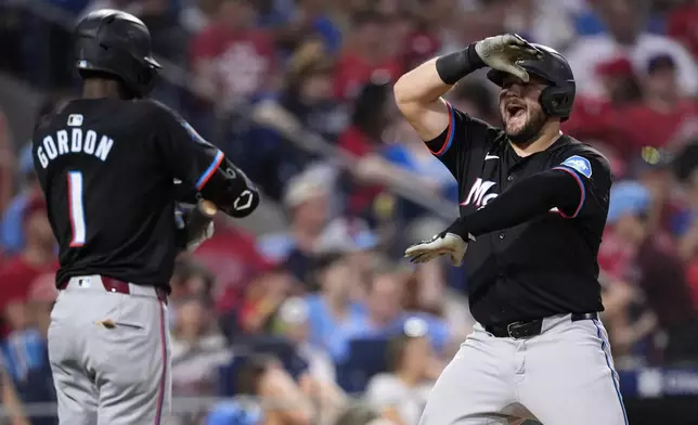 Miami Marlins' Jake Burger, right, celebrates with Nick Gordon after hitting a home run against Philadelphia Phillies pitcher Jeff Hoffman during the eighth inning of a baseball game, Thursday, June 27, 2024, in Philadelphia. (AP Photo/Matt Slocum)