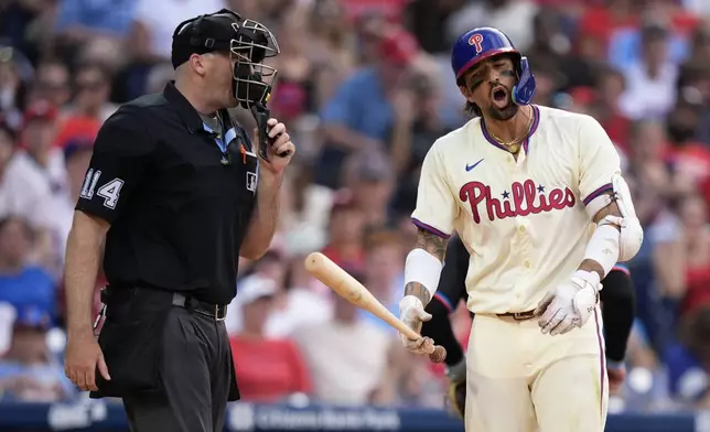 Philadelphia Phillies' Nick Castellanos, right, reacts to umpire Nate Tomlinson after striking out against Miami Marlins pitcher Calvin Faucher during the eighth inning of a baseball game, Saturday, June 29, 2024, in Philadelphia. (AP Photo/Matt Slocum)