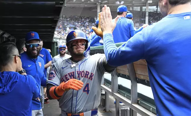 New York Mets' Francisco Alvarez celebrates in the dugout after hitting a home run against the Chicago Cubs in the second inning of a baseball game, Friday, June 21, 2024, in Chicago. (AP Photo/Matt Marton)