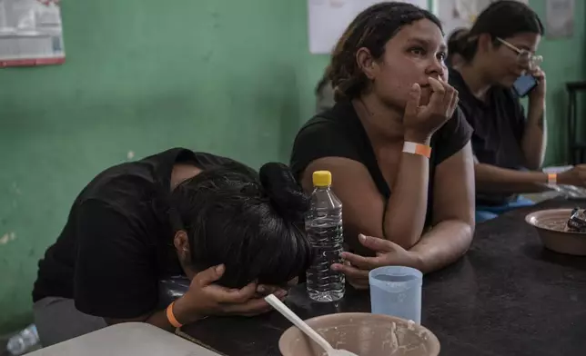 Yeneska Garcia, a Venezuelan migrant, cries into her hands as she eats at the Peace Oasis of the Holy Spirit Amparito shelter in Villahermosa, Mexico, Friday, June 7, 2024. Since the 23-year-old fled Venezuela in January, she trekked days through the jungles of The Darien Gap, narrowly survived being kidnapped by Mexican cartels and waited months for an asylum appointment with the U.S. that never came through. (AP Photo/Felix Marquez)