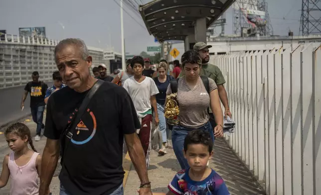 Venezuelan migrants walk after being returned to Villahermosa in southern Mexico by the National Migration Institute, Sunday, June 9, 2024. After the head of Mexico's immigration agency ordered a halt to deportations in December, migrants have been left in limbo as authorities round up migrants across the country and dump them in southern Mexican cities of Villahermosa and Tapachula. (AP Photo/Felix Marquez)