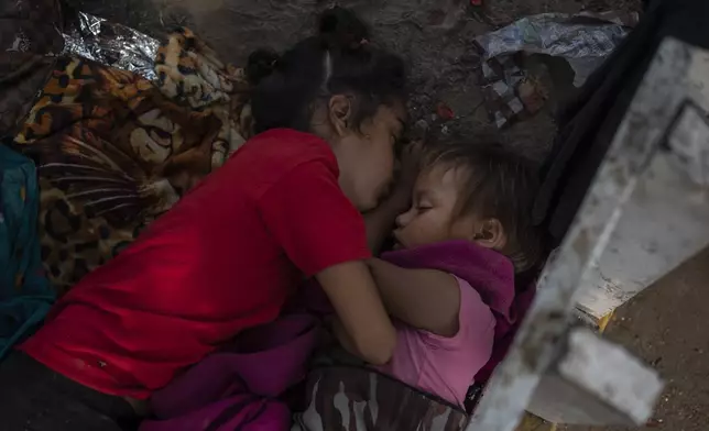 The Bolaños sisters from Venezuela sleep on the ground outside a bus terminal where they are living with their single mother Keilly and two other siblings, alongside other migrants in Villahermosa, Mexico, Saturday, June 8, 2024. Their mother said she was seeking asylum hoping to treat her her four-year-old daughter, right, for leukemia, due to lack of access to medical care back in Venezuela. (AP Photo/Felix Marquez)