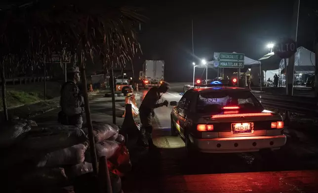 A National Guard officer checks a vehicle at the immigration checkpoint in Nuevo Teapa in southern Mexico, Saturday, June 8, 2024. Mexico is under pressure from the U.S. to block millions of migrants headed north. (AP Photo/Felix Marquez)