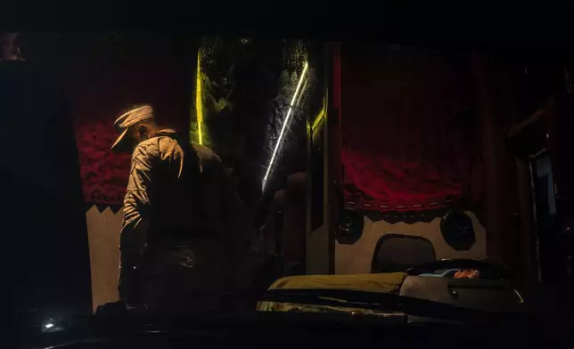 A National Guard officer ispects the interior of a passenger bus at an immigration checkpoint in Nuevo Teapa, southern Mexico, late Saturday, June 8, 2024. Mexico is under pressure from the U.S. to block millions of migrants headed north. (AP Photo/Felix Marquez)