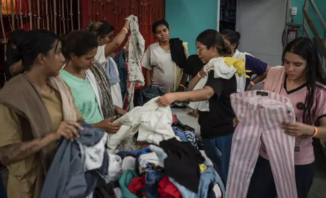 Venezuelan migrants pick out donated clothing at the Peace Oasis of the Holy Spirit Amparito shelter in Villahermosa, Mexico, Friday, June 7, 2024. After the head of Mexico's immigration agency ordered a halt to deportations in December, migrants have been left in limbo as authorities round up migrants across the country and dump them in the southern Mexican cities of Villahermosa and Tapachula. (AP Photo/Felix Marquez)