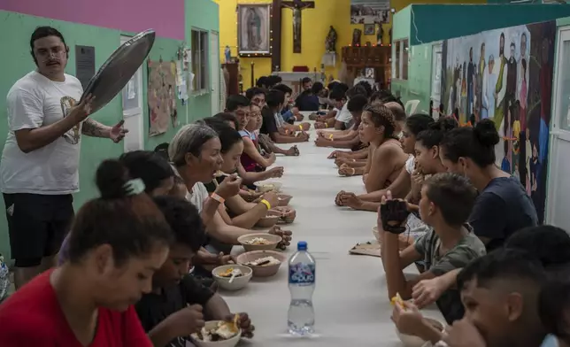 Migrants eat lunch at the Peace Oasis of the Holy Spirit Amparito shelter in Villahermosa, Mexico, Friday, June 7, 2024. After the head of Mexico's immigration agency ordered a halt to deportations in December, migrants have been left in limbo as authorities round up migrants across the country and dump them in the southern Mexican cities of Villahermosa and Tapachula. (AP Photo/Felix Marquez)