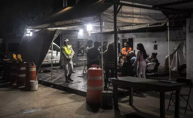 Fabiana Bellizar, a Venezuelan migrant, is detained with other migrants after being removed from a bus, at an immigration checkpoint in La Venta, Mexico, Saturday, June 8, 2024. After being taken off the bus, the group of migrants begged authorities not to release them, but to help them return to Venezuela. (AP Photo/Felix Marquez)