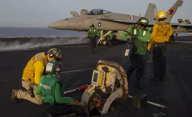 Crew members work during take off operations on the deck of the USS Dwight D. Eisenhower in the Red Sea on Tuesday, June 11, 2024. (AP Photo/Bernat Armangue)