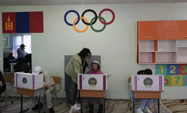 Mongolians prepare their votes at a polling station in Ulaanbaatar, Mongolia, Friday, June 28, 2024. Voters in Mongolia are electing a new parliament on Friday in their landlocked democracy that is squeezed between China and Russia, two much larger authoritarian states (AP Photo/Ng Han Guan)