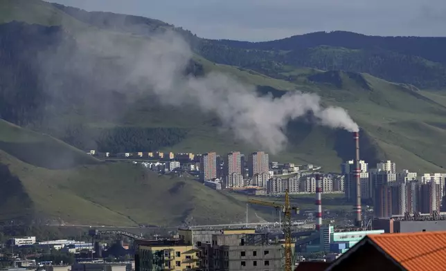 A power plant churns out smoke near residential buildings on the outskirts of Ulaanbataar, Mongolia, Thursday, June 27, 2024. The city has some of the worst air in the world. Annual levels of fine, inhalable particles known as PM2.5 surpass levels considered safe by the World Health Organization by nearly 9-times. Children are particularly at risk. (AP Photo/Ng Han Guan)